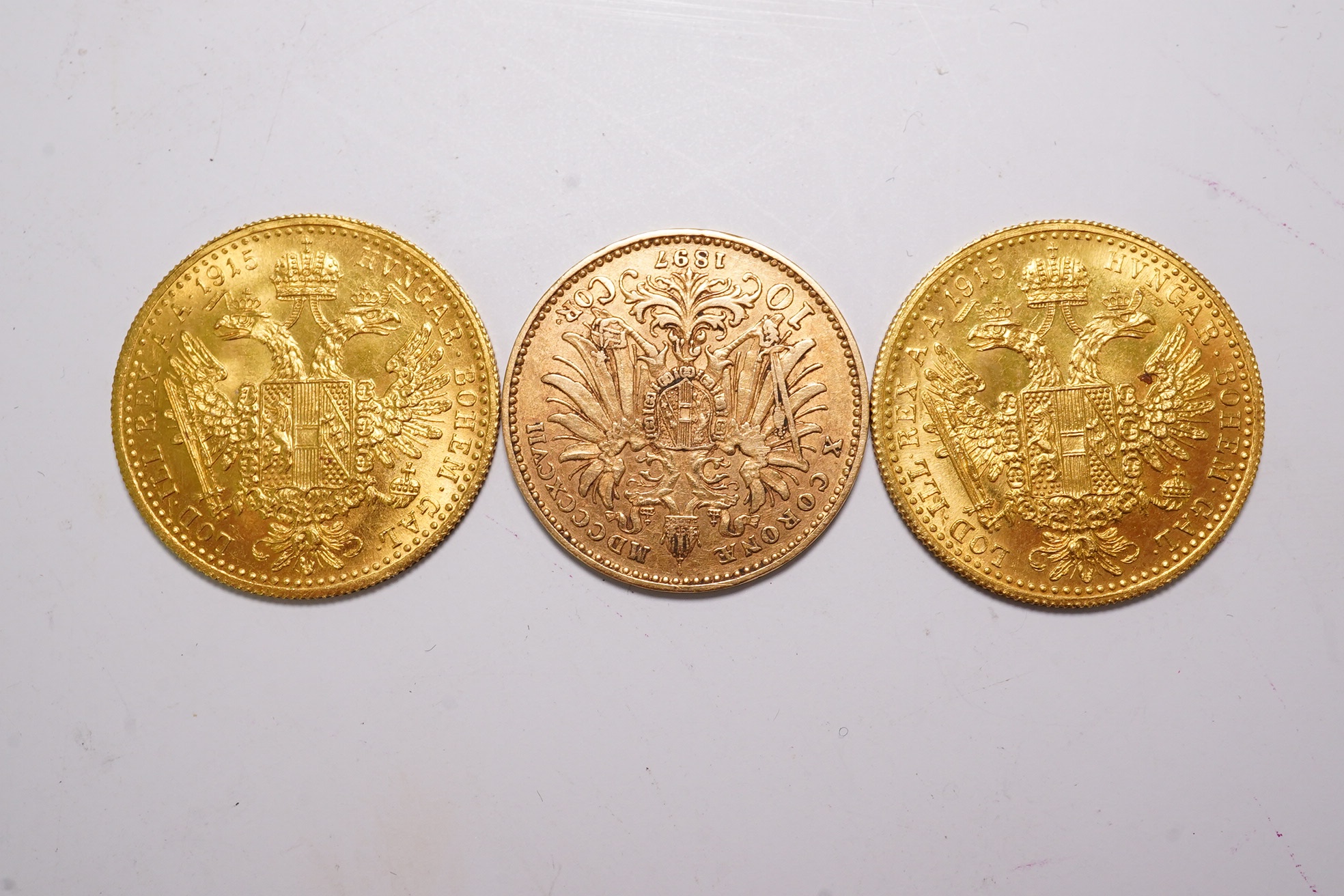 Austrian Empire gold coins, Francis Joseph I, two individual gold 1 ducat, 1915 re-strikes, UNC and a gold 10 corona, 1897, good VF (3)